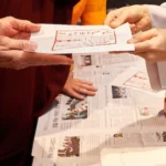Monache buddiste che si scambaino un foglio religioso